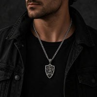 Homme portant le Collier Gloire de l’Archange en acier inoxydable avec tenue noire et veste sombre.