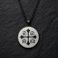 Collier Héritage Sacré en acier inoxydable noir avec médaillon rond IC XC NI KA sur fond anthracite
