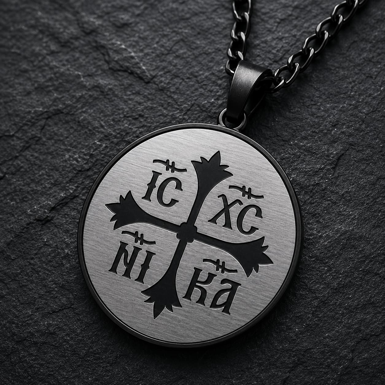 Gros plan du médaillon IC XC NI KA du Collier Héritage Sacré en acier inoxydable
