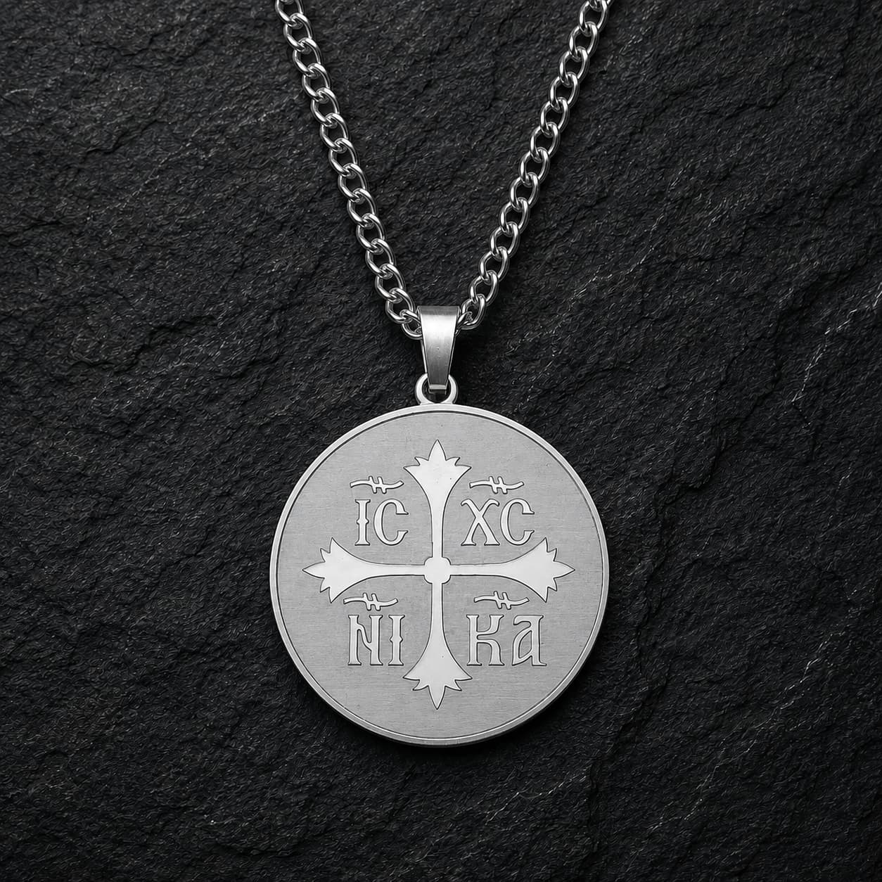 Variante argentée du Collier Héritage Sacré en acier inoxydable sur fond anthracite texturé