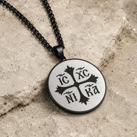 Collier Héritage Sacré en acier inoxydable noir présenté en angle sur pierre médiévale claire