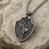 Vue angle du Collier Honneur de Saint Michel en acier inoxydable sur pierre médiévale claire