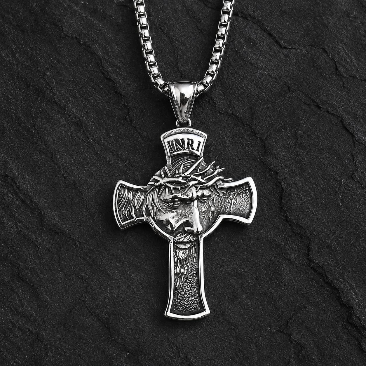 Collier Inri Sacré en acier inoxydable argenté sur fond anthracite texturé