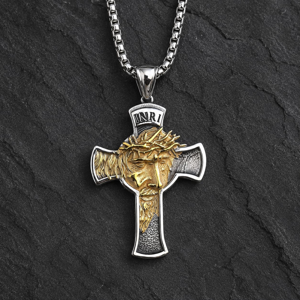 Collier Inri Sacré en acier inoxydable argenté et doré sur fond anthracite texturé