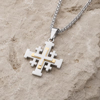 Vue angle du Collier de l’Ordre du Saint Sépulcre en acier inoxydable avec croix argentée et dorée sur pierre médiévale claire