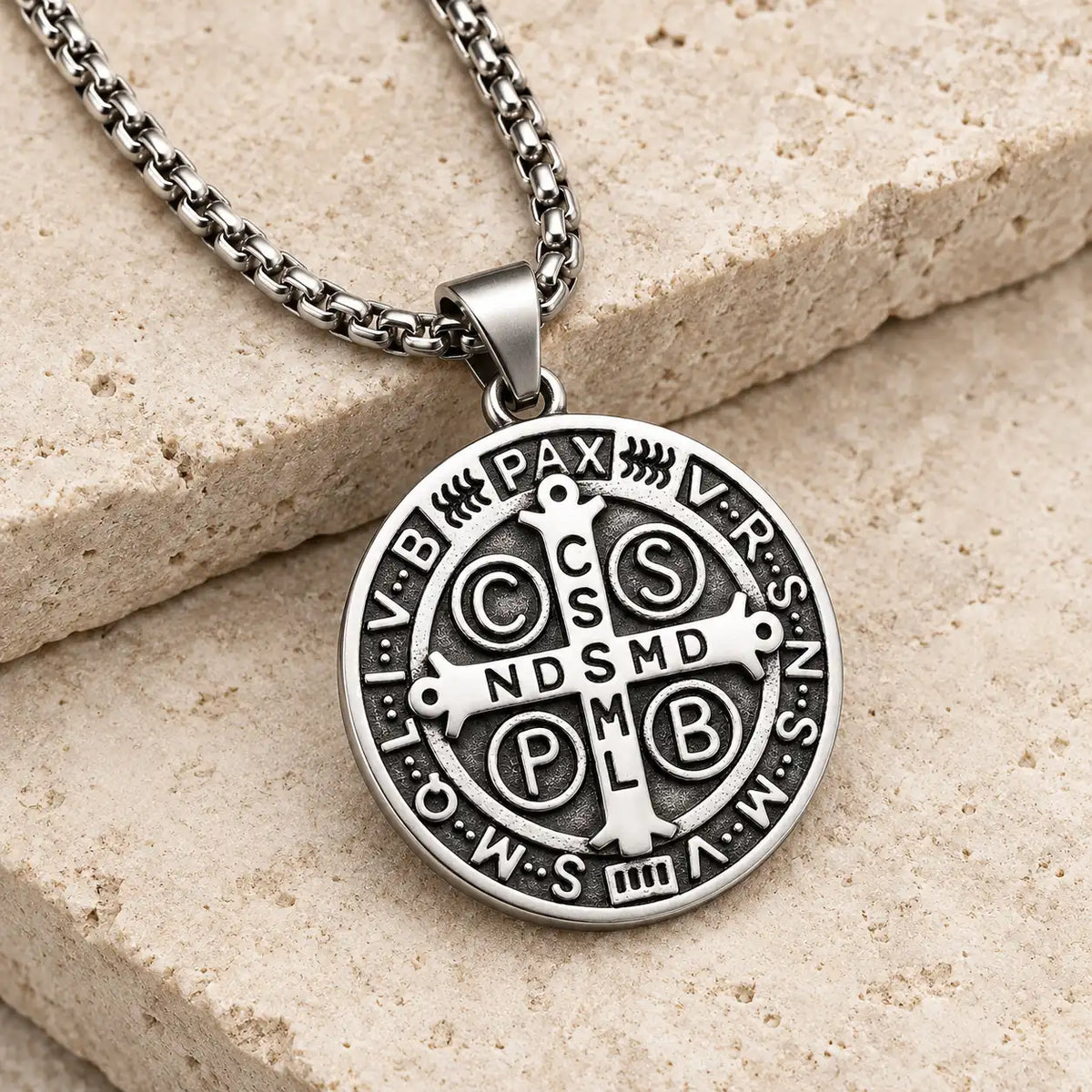 Collier de la Protection de Saint Benoît en argent vieilli présenté sur pierre claire