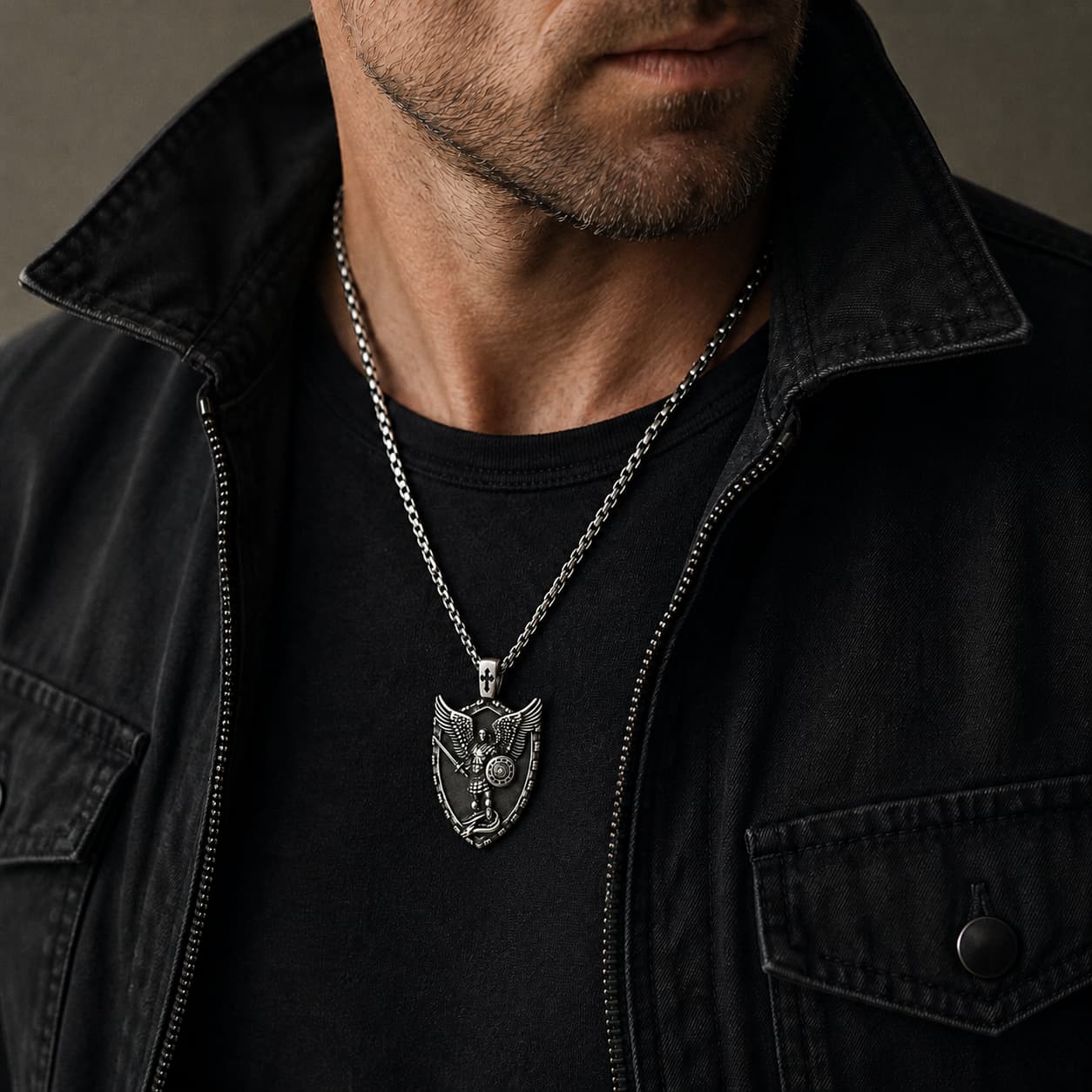 Collier Puissance de Saint Michel porté par un homme avec tenue noire et veste sombre