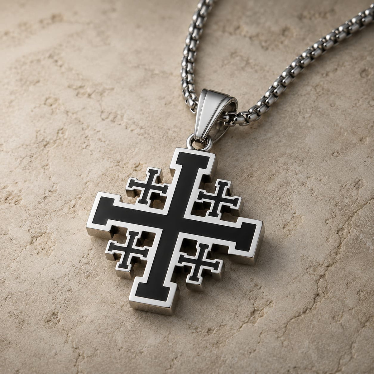 Vue angle du collier Sacré de l’Ordre de Jérusalem argenté et noir sur pierre médiévale claire