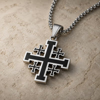 Vue angle du collier Sacré de l’Ordre de Jérusalem argenté et noir sur pierre médiévale claire