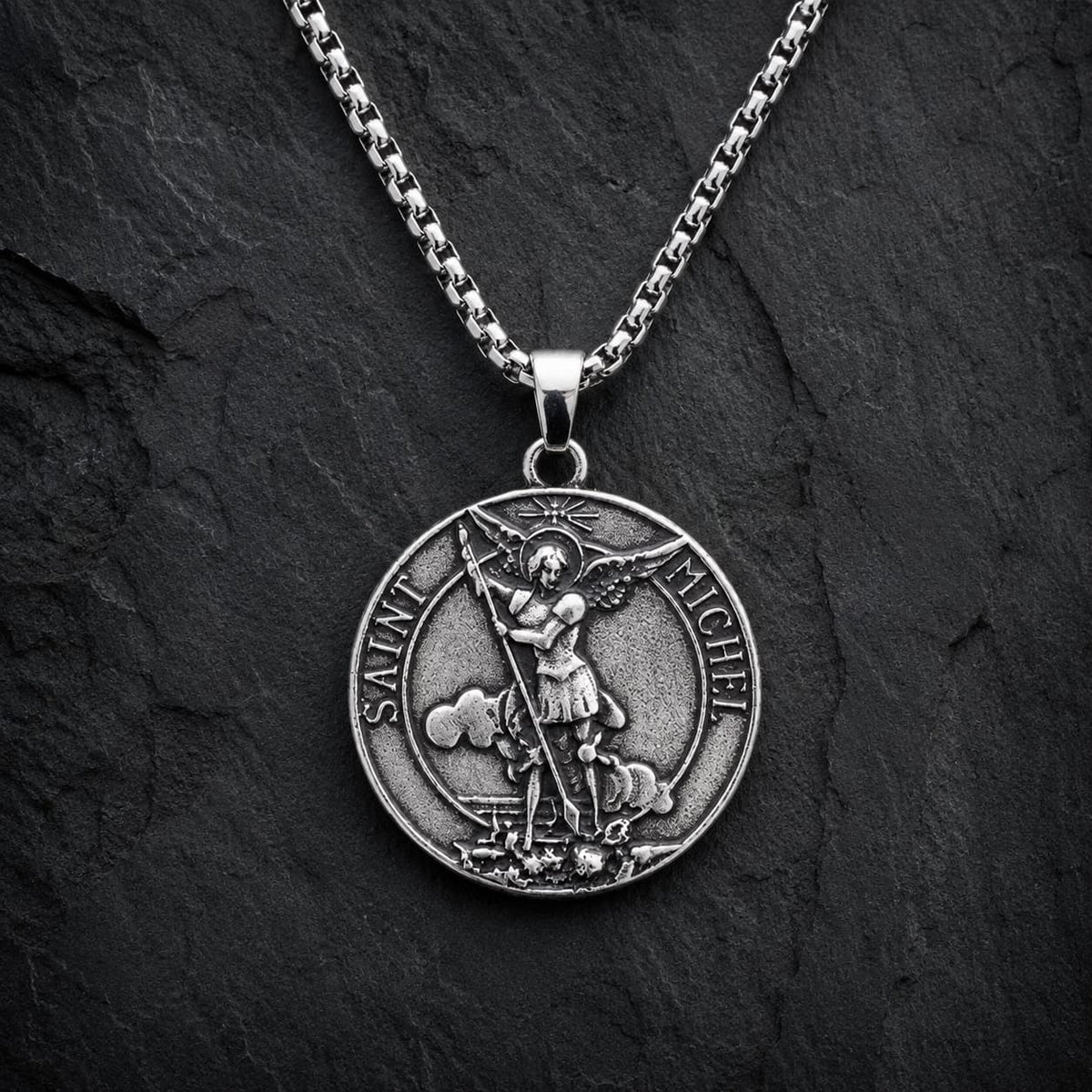 Collier Saint Michel Protecteur en acier inoxydable sur fond anthracite texturé ardoise sombre