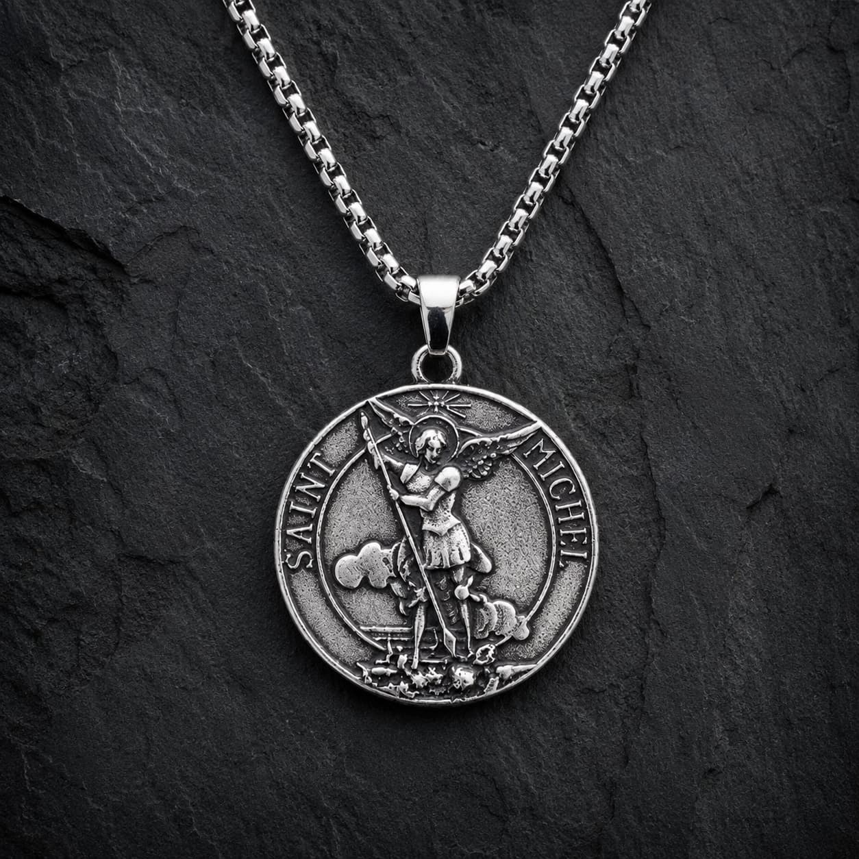Collier Saint Michel Protecteur en acier inoxydable sur fond anthracite texturé ardoise sombre