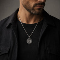 Homme portant un Collier de Saint Michel Protecteur en acier inoxydable avec tenue noire et veste sombre