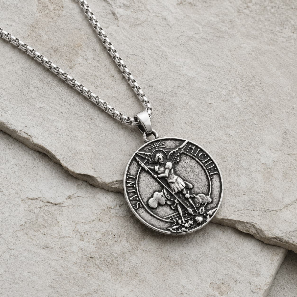 Collier Saint Michel Protecteur en acier inoxydable vue angle 3 4 sur pierre médiévale claire beige gris