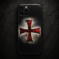 Coque iPhone Croix Templier en silicone noire avec croix rouge effet usé sur fond de pierre sombre.