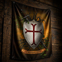 Drapeau du Bouclier Templier en polyester présenté en vue inclinée sur bois ancien sombre avec plis naturels du tissu.
