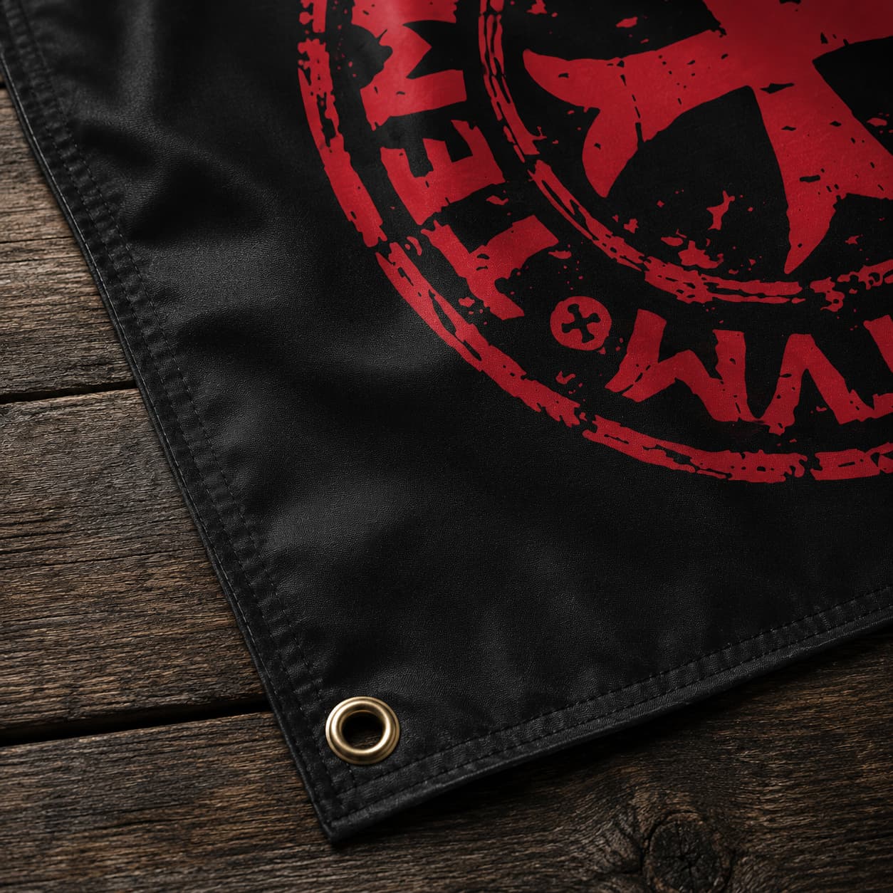 Détail du Drapeau Sigillum Templi en polyester avec œillet métallique, couture noire et texture du tissu sur bois ancien.