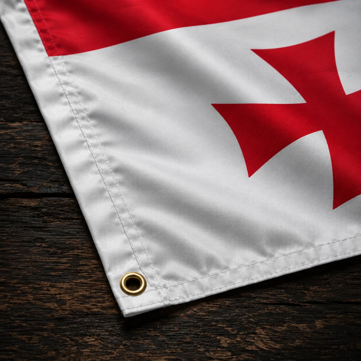 Détail du coin du Drapeau Templier Blanc aux Cinq Croix en polyester avec œillet métallique et couture visible sur le tissu.