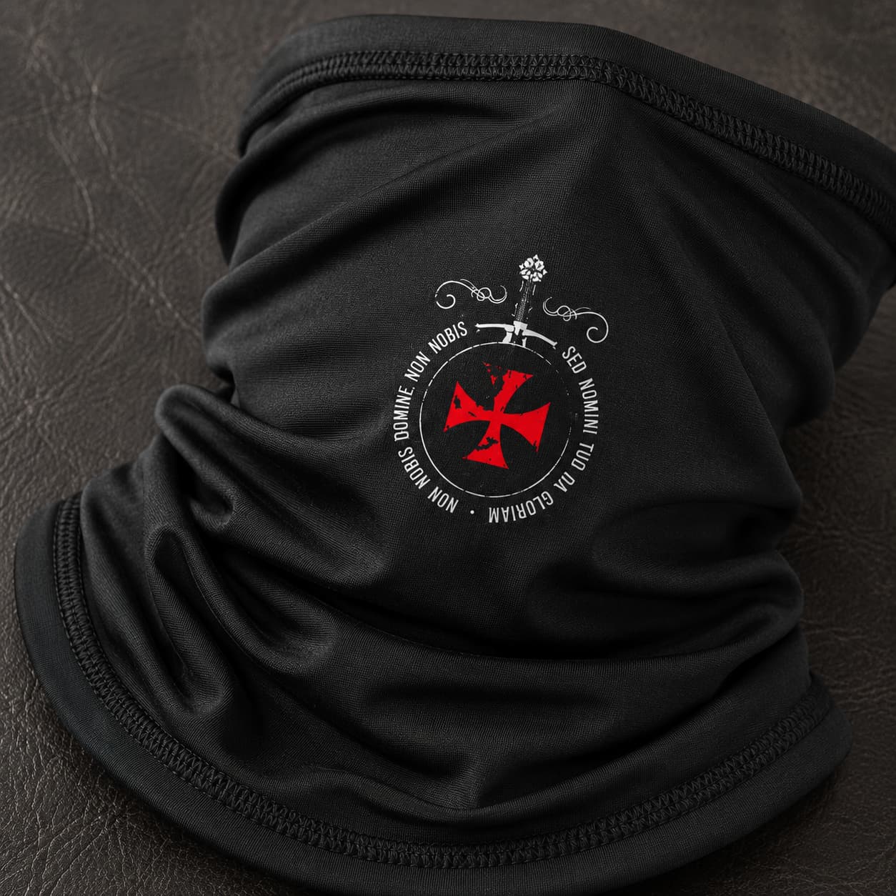 Gros plan du motif croix rouge et Sed Nomini sur l’Écharpe Sed Nomini en polyester noir.