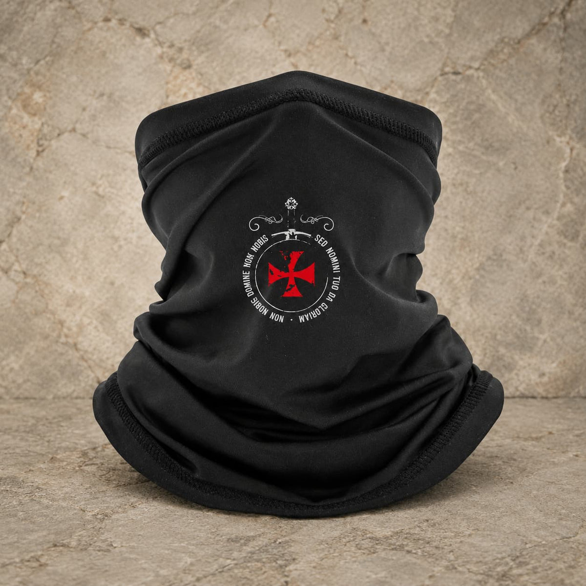 Écharpe Sed Nomini en polyester noir avec croix rouge sur fond pierre médiévale claire.