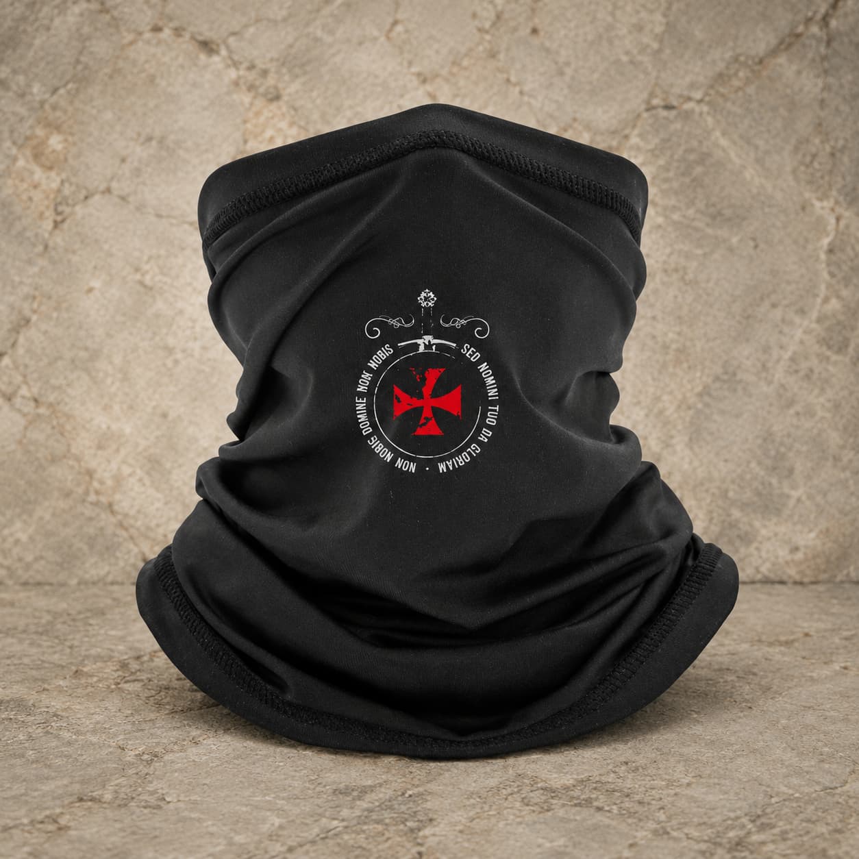 Écharpe Sed Nomini en polyester noir avec croix rouge sur fond pierre médiévale claire.