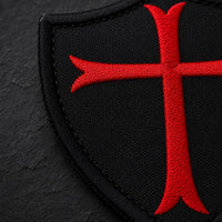 Gros plan sur la broderie de la croix rouge de l’Écusson Chevalier Croisé en tissu brodé.