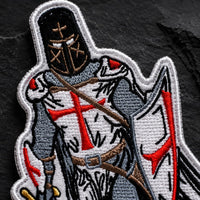 Gros plan sur l’Écusson Chevalier Templier en tissu brodé, avec casque, croix rouge, bouclier et fils détaillés.