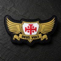 Gros plan sur le Patch Deus Vult du Croisé en PVC souple montrant le bouclier, la croix rouge, les ailes dorées et le texte.