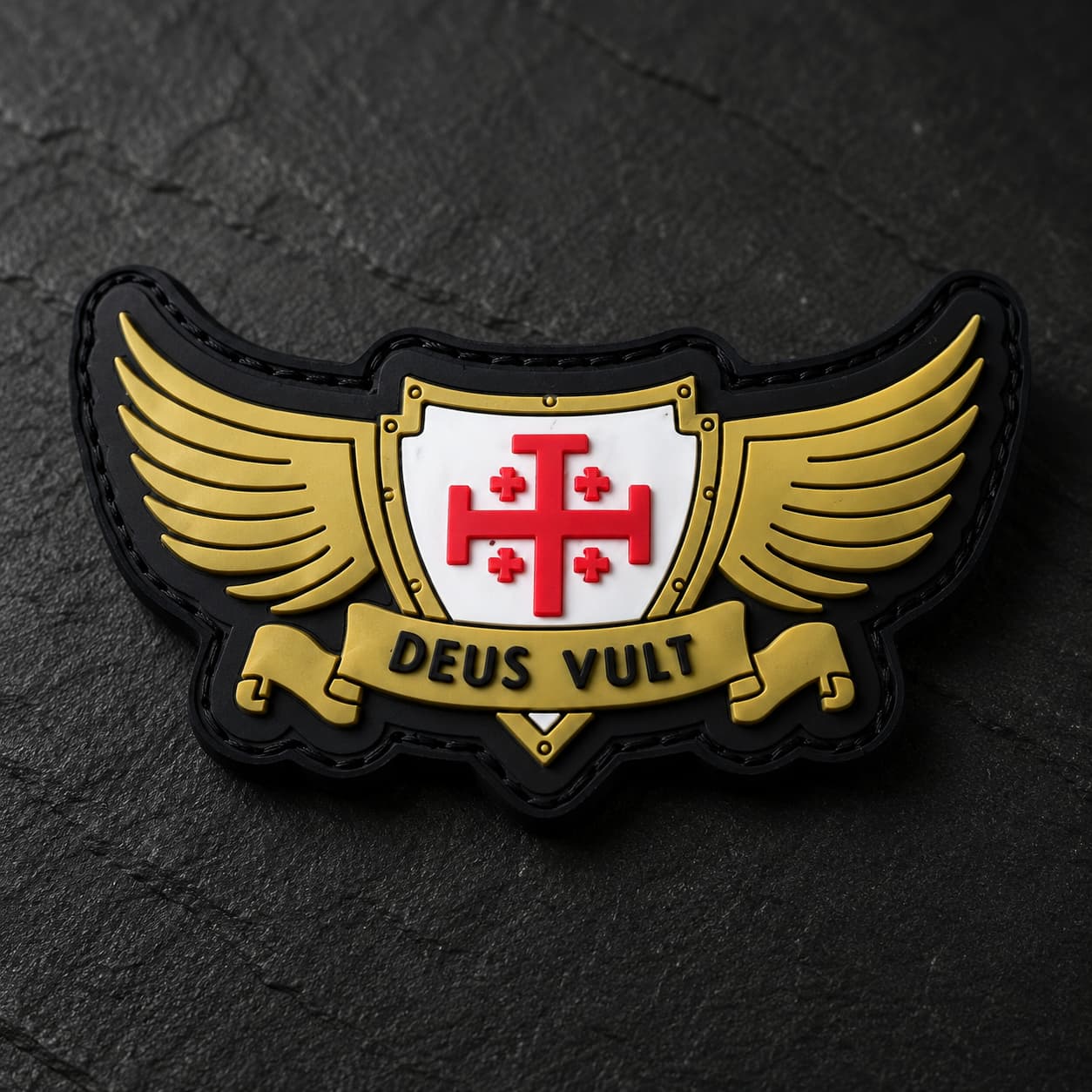 Gros plan sur le Patch Deus Vult du Croisé en PVC souple montrant le bouclier, la croix rouge, les ailes dorées et le texte.