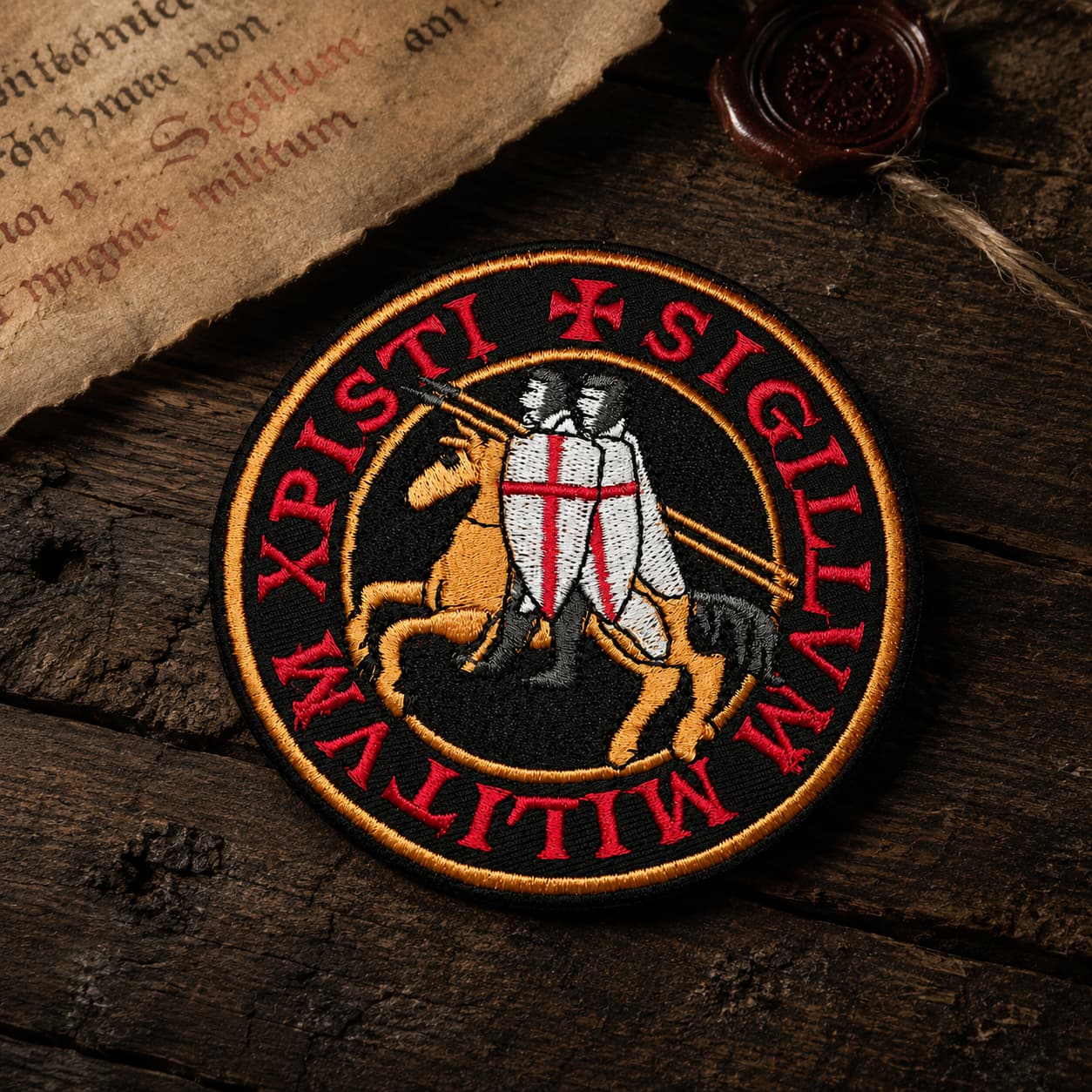 Patch Écusson de l’Exécuteur en tissu brodé présenté en plusieurs tailles sur fond en bois sombre.