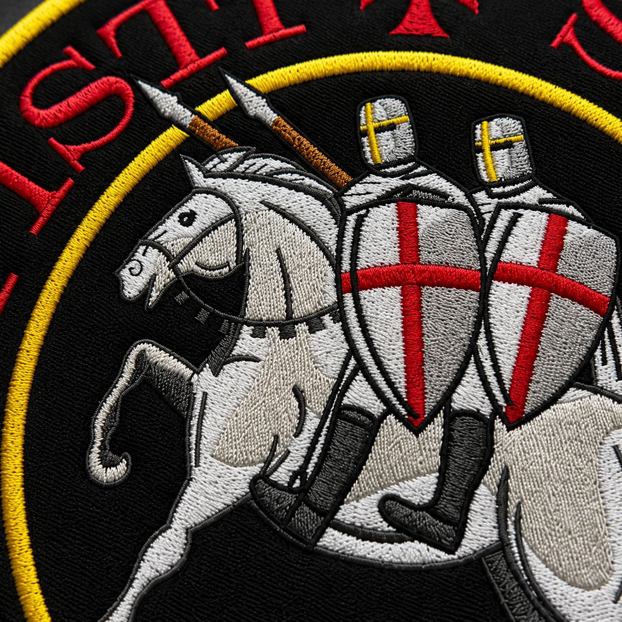 Gros plan sur la broderie du patch Écusson Grand Sigillum Militum Xpisti en tissu brodé, montrant les chevaliers, le cheval et les détails des coutures.
