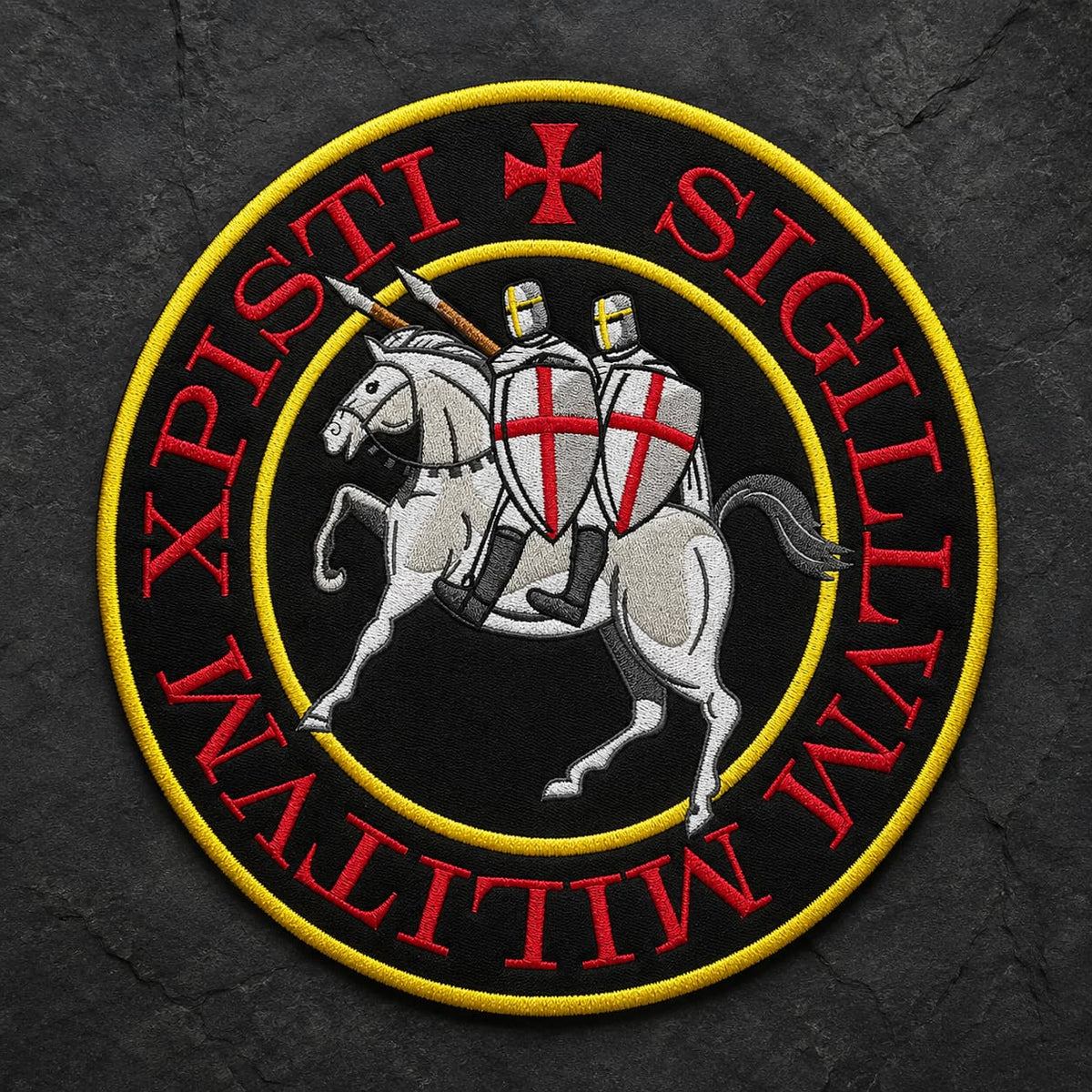 Écusson Grand Sigillum Militum Xpisti en tissu brodé sur fond d’ardoise sombre, avec chevaliers templiers, cheval blanc et bordure jaune.