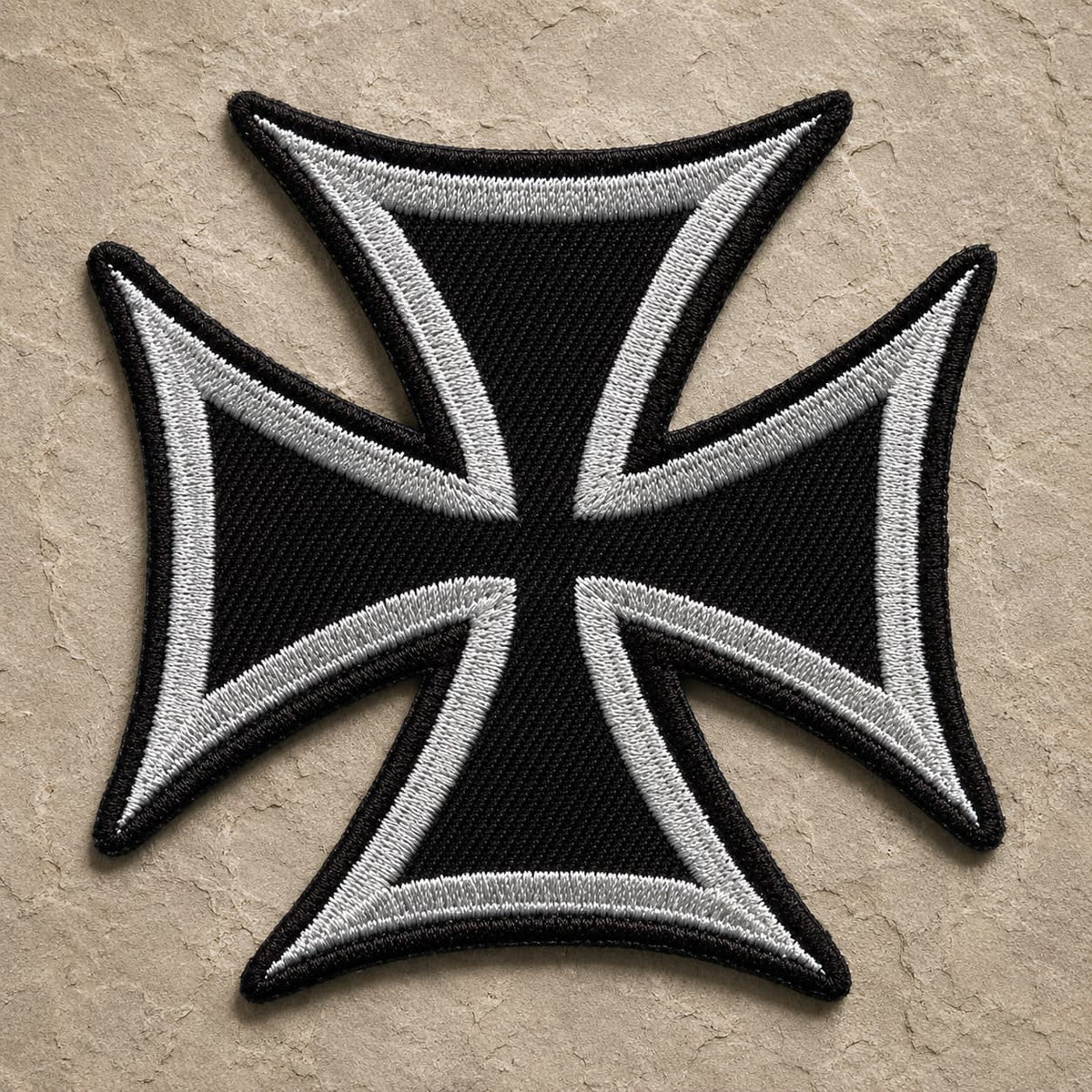 Patch Écusson de l'Ordre Teutonique en tissu brodé sur fond de pierre sombre.