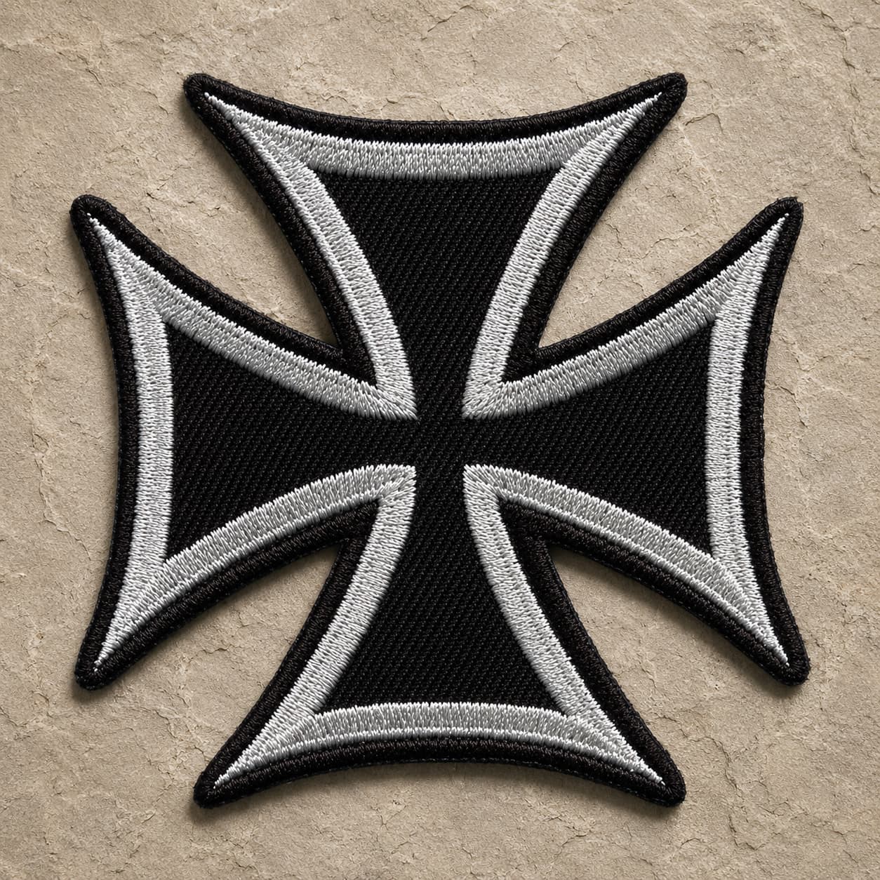 Patch Écusson de l'Ordre Teutonique en tissu brodé sur fond de pierre sombre.