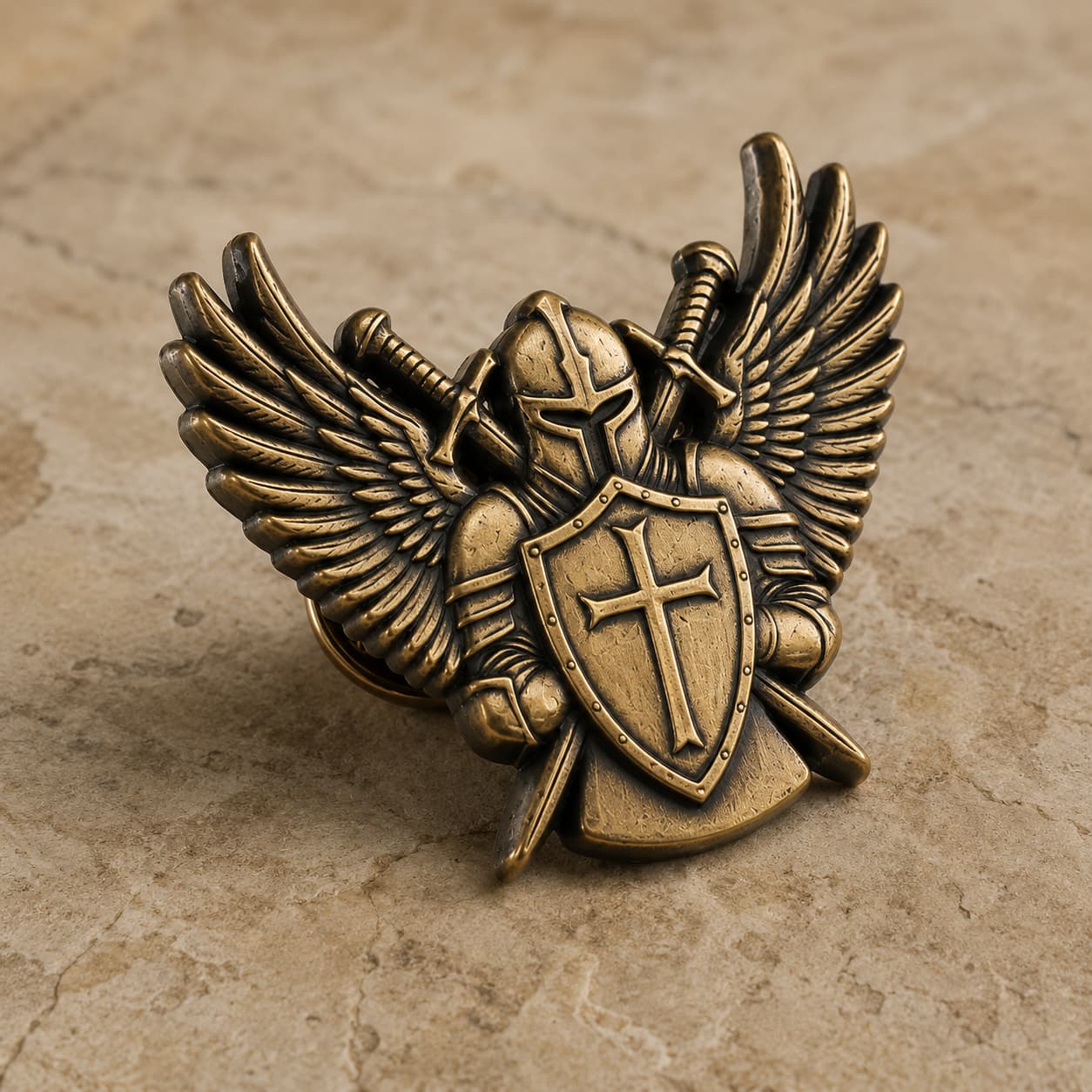Pin's Ailes du Templier en acier inoxydable vu en angle sur pierre claire avec détails du casque, des ailes et du bouclier.