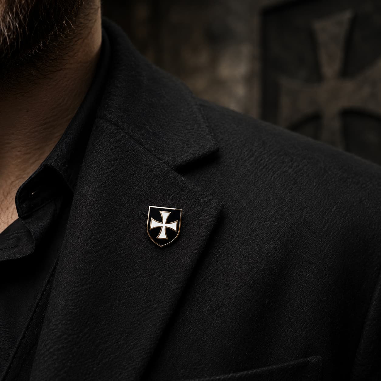 Pin’s Bouclier du Temple en alliage métallique porté sur une veste noire dans une ambiance médiévale sombre.