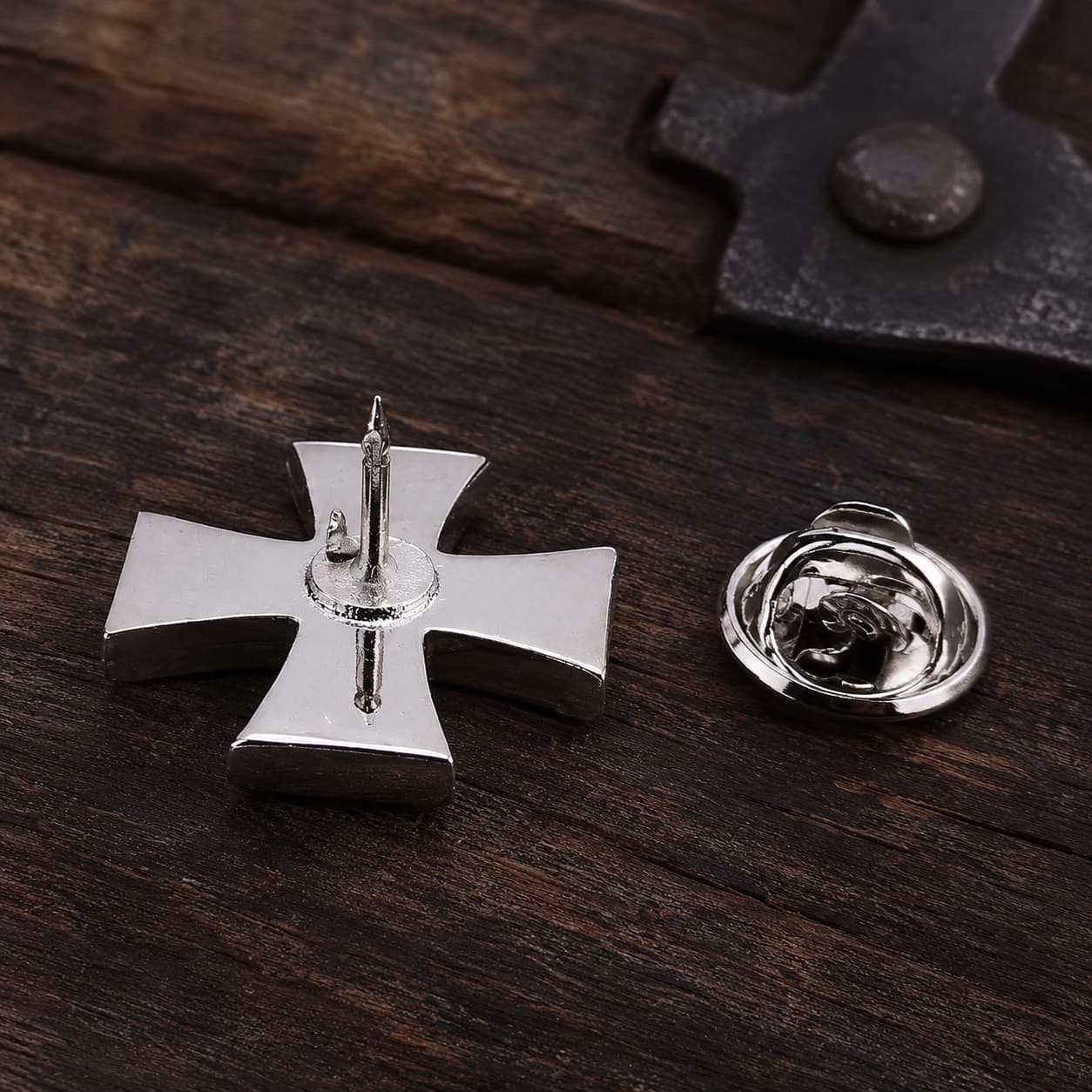 Vue arrière du Pin’s Croix du Temple en alliage métallique avec son fermoir sur bois ancien sombre.