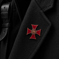 Pin's du Sceau Templier en cuivre fixé sur un vêtement noir dans une ambiance sombre et premium.