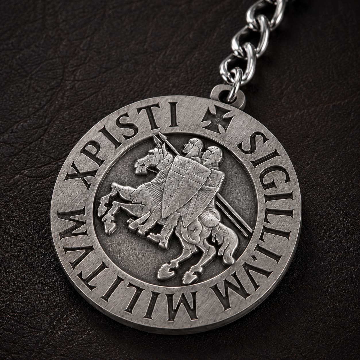 Gros plan de la médaille du Porte-Clé du Sceau Templier en alliage métallique sur fond cuir sombre.