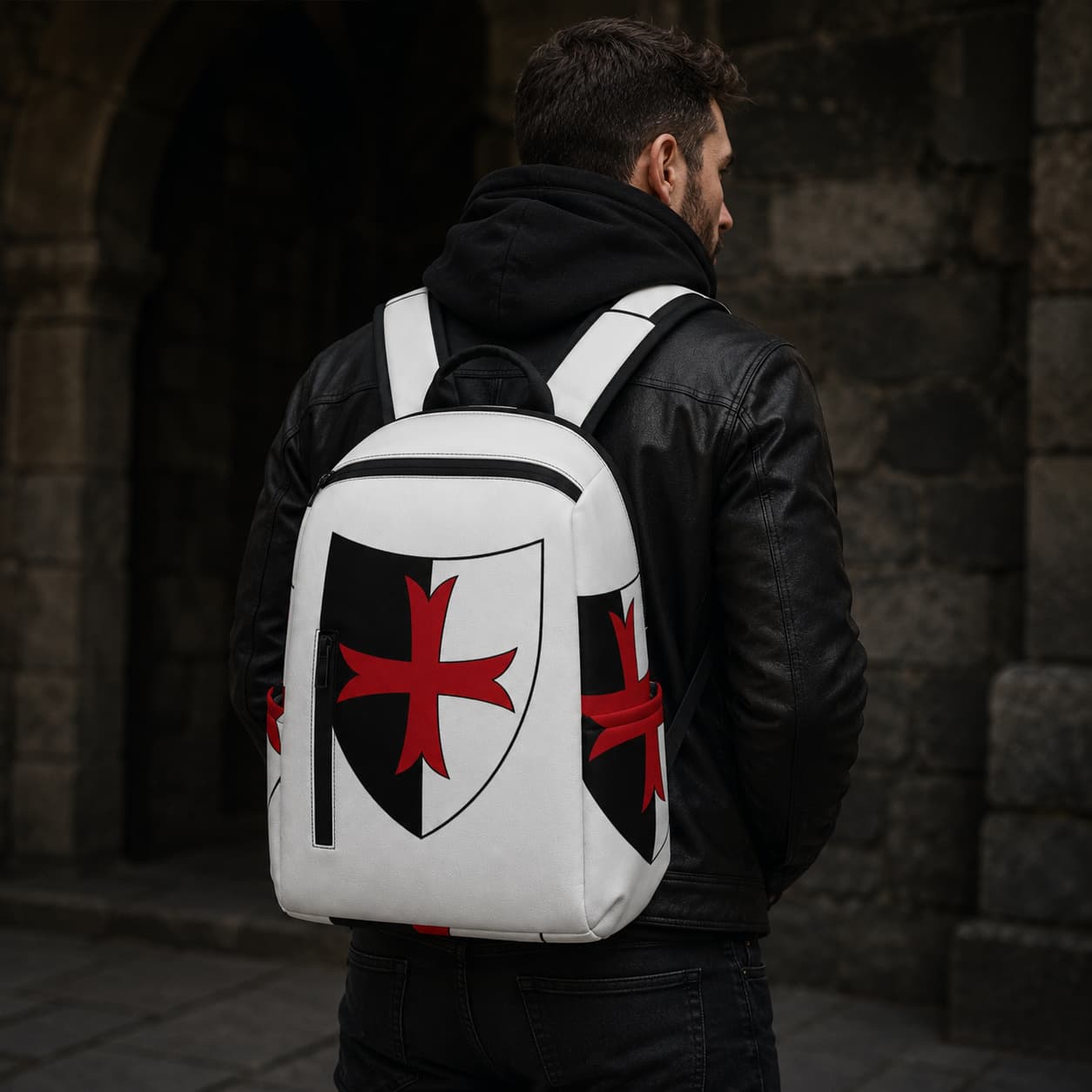 Sac à dos Sceau Templier en polyester porté par un homme en tenue sombre devant un mur de pierre.