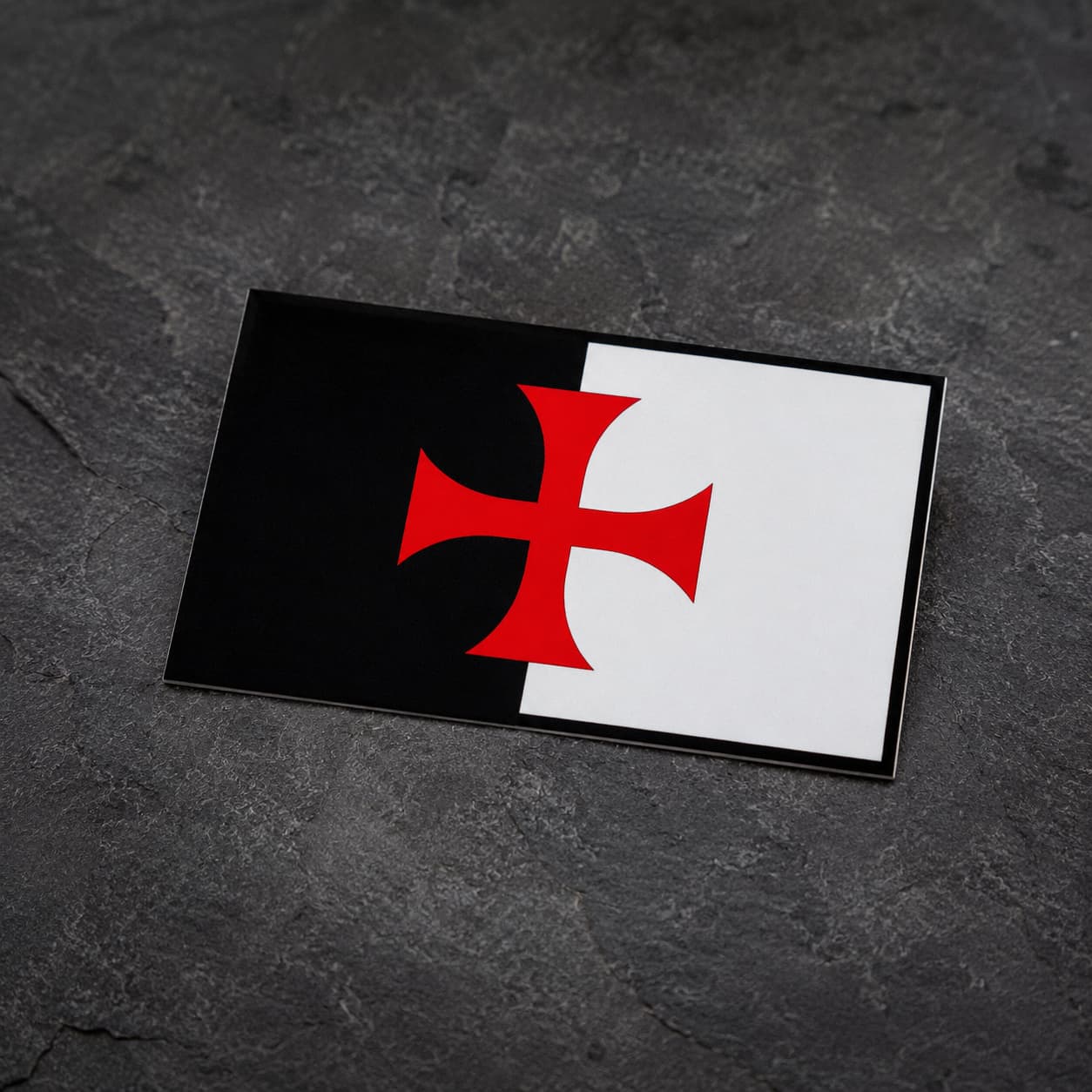 Sticker Bannière du Temple en vinyle présenté en vue inclinée sur fond ardoise sombre.