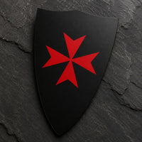 Gros plan du Sticker Bouclier Templier en vinyle adhésif sur fond d’ardoise sombre, avec croix templière rouge bien visible.