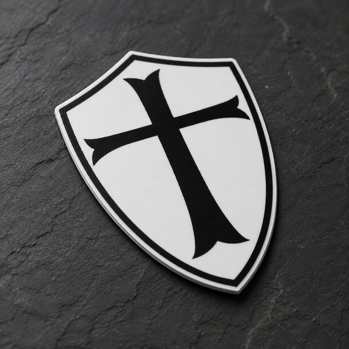 Sticker du Chevalier Templier en vinyle résistant en vue inclinée sur ardoise sombre, avec découpe et finition vinyle visibles.
