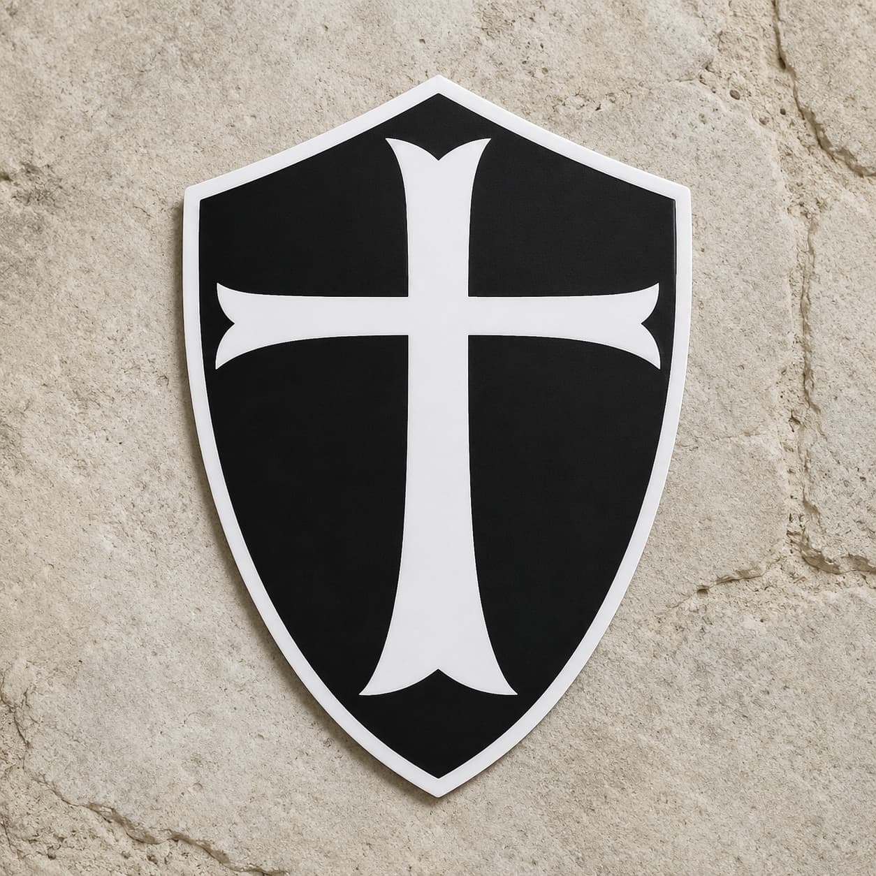 Sticker du Chevalier Templier en vinyle résistant présenté de face sur pierre claire, avec bouclier noir et croix blanche.