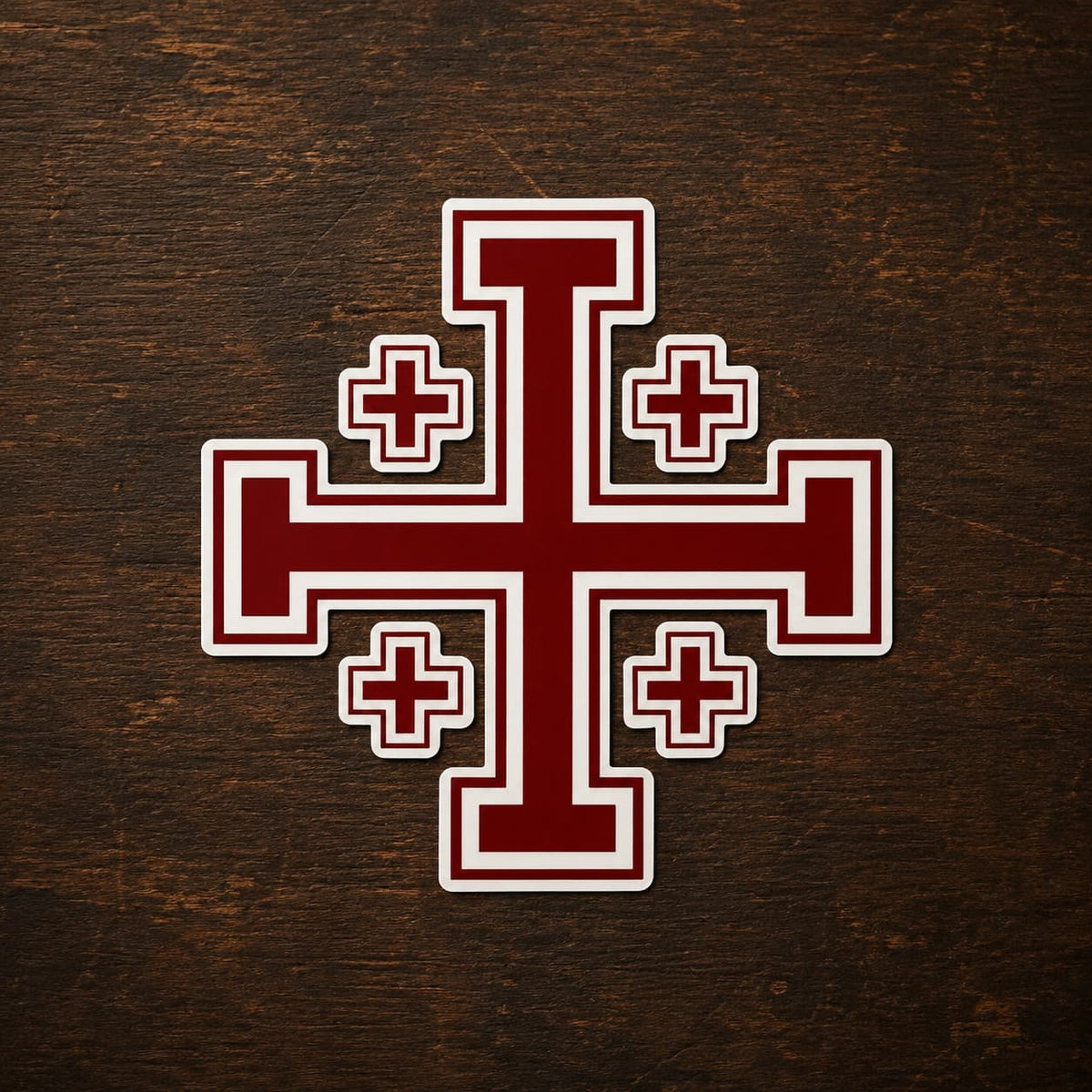 Sticker de l’Ordre de Saint Sépulcre en vinyle adhésif avec croix de Jérusalem rouge sur bois ancien sombre.