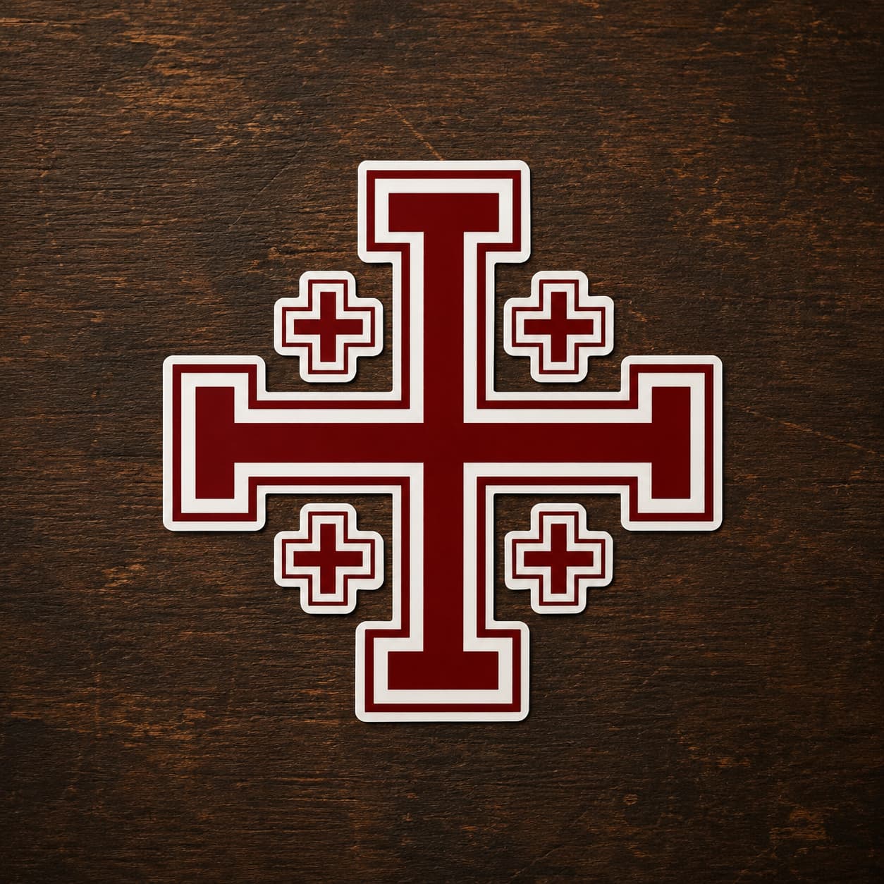 Sticker de l’Ordre de Saint Sépulcre en vinyle adhésif avec croix de Jérusalem rouge sur bois ancien sombre.