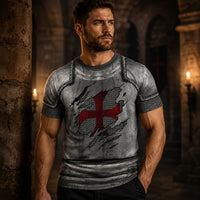 Homme portant le T-Shirt Armure du Croisé avec motif d’armure médiévale et croix rouge dans un décor sombre.