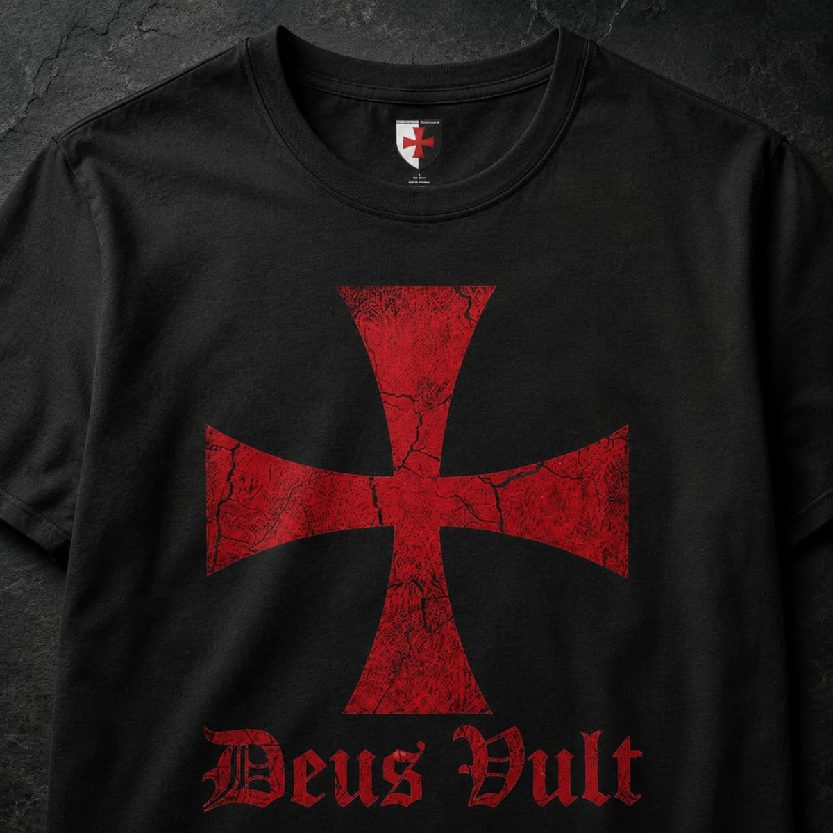 Gros plan du motif Deus Vult avec croix templière rouge imprimée sur t-shirt noir en coton.
