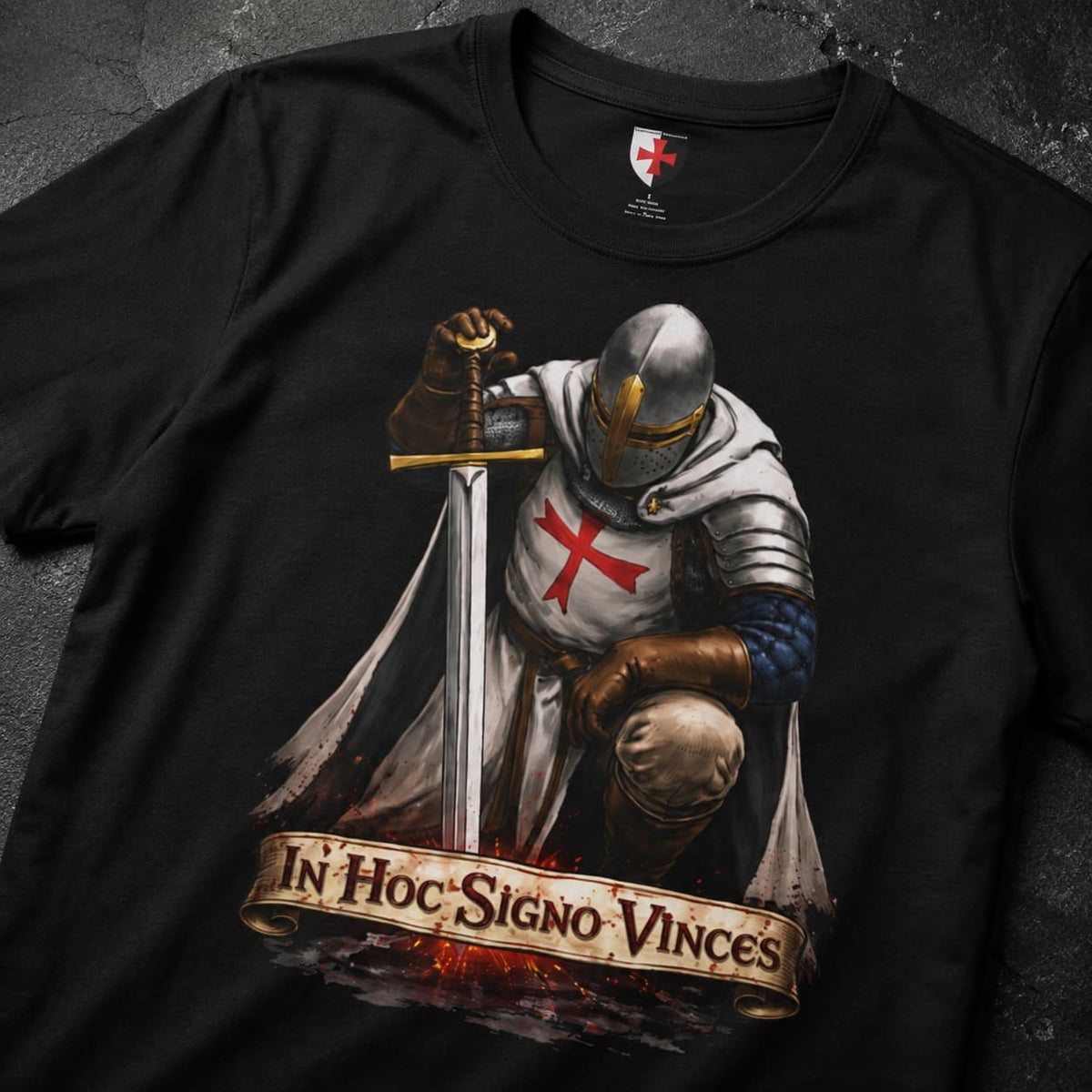Gros plan du T-Shirt In Hoc Signo Vinces avec chevalier en armure, épée et bannière latine.