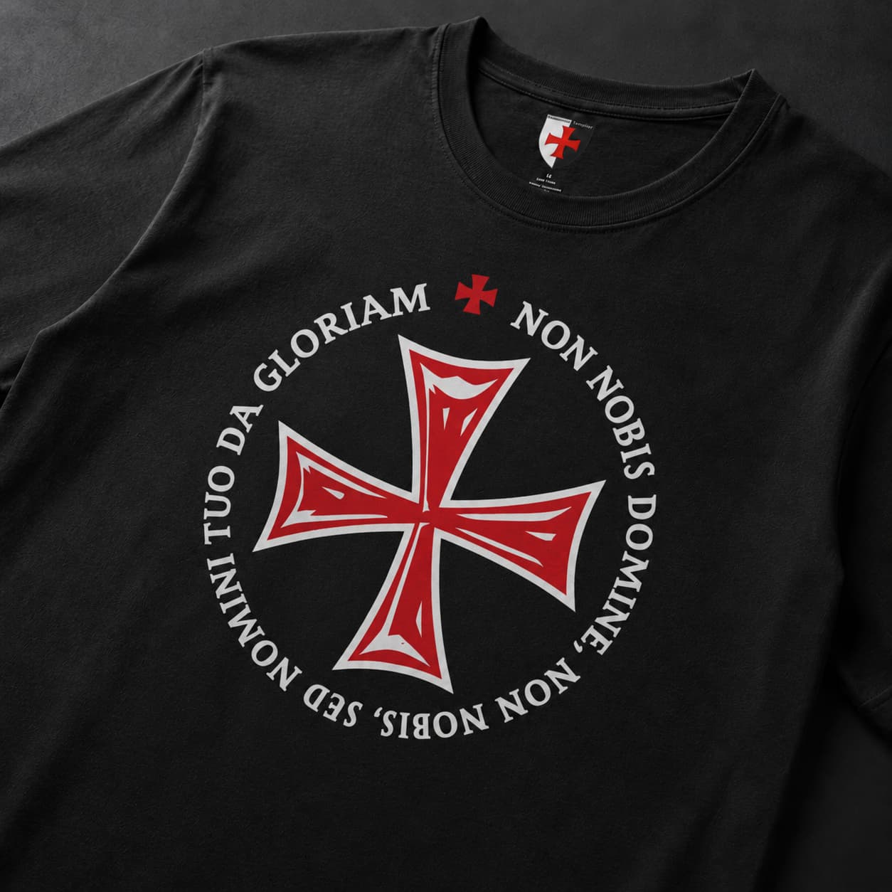 Gros plan du T-Shirt Non Nobis Domine en coton noir avec croix rouge et devise circulaire.