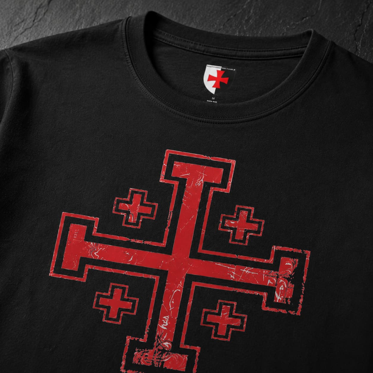 Gros plan du motif croix de Jérusalem rouge imprimé sur le T-Shirt Sceau du Saint Sépulcre en coton noir.